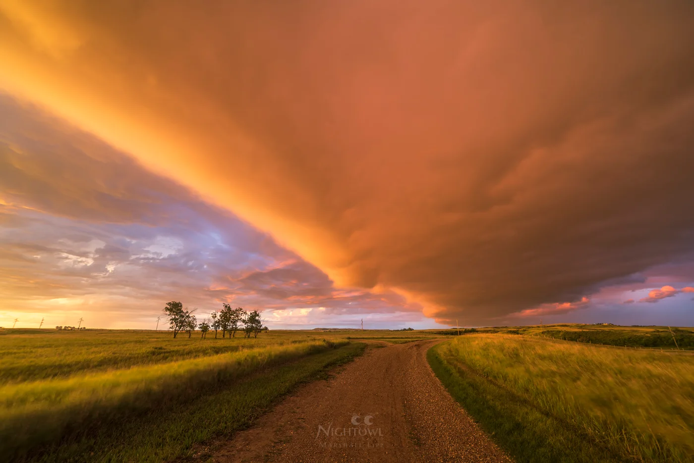 A storm-lit road across the prairie